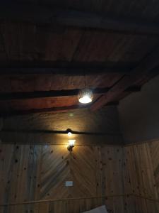 a room with a wooden ceiling with a light on it at Nature Valley Homestay Shaukiyathal in Panuānaula
