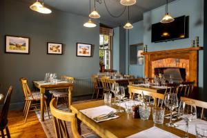 a restaurant with tables and chairs and a fireplace at The Olde Coach House Inn in Ashby Saint Ledgers
