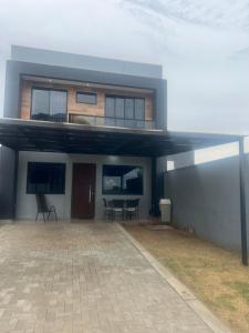 a house with a patio with a table and chairs at Sobrado confortavel e central in Foz do Iguaçu