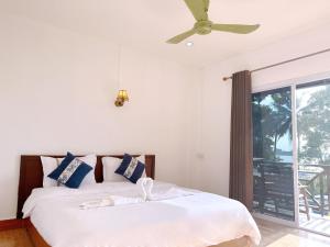 a bedroom with a bed and a ceiling fan at Chandala Hotel in Thakhek