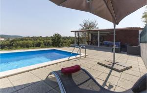 a chair with an umbrella next to a swimming pool at Villa Ana Istra in Novaki Motovunski +17 photos