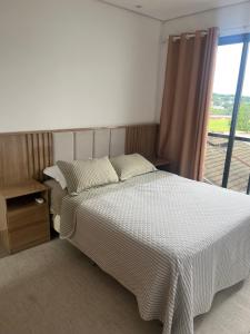 a bedroom with a large bed with a window at Sobrado confortavel e central in Foz do Iguaçu