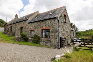 ein altes Steinhaus am Straßenrand in der Unterkunft Ffesant in Haverfordwest