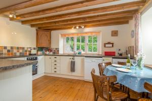a kitchen with a table with a blue table cloth at Castle View in Carew +22 photos