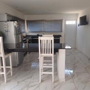 a kitchen with a table and two white chairs at Ideal CASA EN NECOCHEA in Necochea