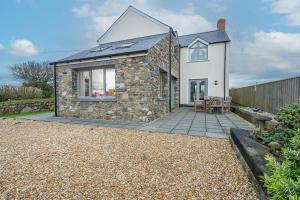 ein Steinhaus mit einer Terrasse davor in der Unterkunft Skylark Cottage in Haverfordwest