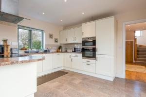 eine große Küche mit weißen Schränken und Geräten in der Unterkunft Skylark Cottage in Haverfordwest