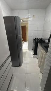 a kitchen with a stainless steel refrigerator in a room at Apartamento A 700m da orla mais bonita do país no bairro Atalaia in Santa Maria +8 photos