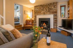 ein Wohnzimmer mit Couch und Kamin in der Unterkunft Swiss Cottage in Tenby