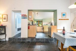 eine Küche und ein Wohnzimmer mit Tisch und Stühlen in der Unterkunft Swiss Cottage in Tenby