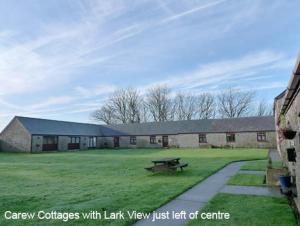 a large building with a picnic table in a field at Lark View in Pembroke +20 photos