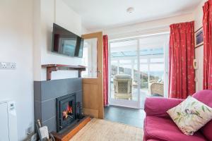 a living room with a fireplace and a tv at Agos Y Mor in Haverfordwest