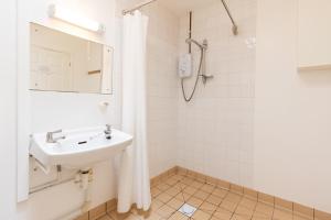 biała łazienka z umywalką i prysznicem w obiekcie Blueberry Cottage w mieście Haverfordwest +25 zdjęć
