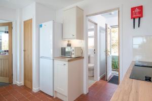 a kitchen with a white refrigerator and a microwave at Agos Y Mor in Haverfordwest