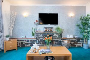 ein Wohnzimmer mit einem Tisch und einem Steinkamin in der Unterkunft Llwyndyrys in Haverfordwest