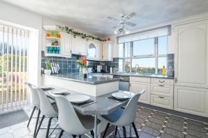 eine Küche mit einem Tisch und Stühlen in einer Küche in der Unterkunft Llwyndyrys in Haverfordwest