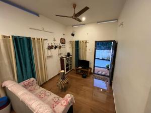 バルカラにあるPhoenix homestayのソファとテレビのあるリビングルーム
