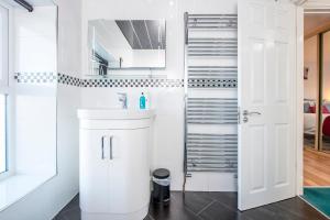 ein weißes Badezimmer mit einem Waschbecken und einer Treppe in der Unterkunft Llwyndyrys in Haverfordwest + 31 Fotos