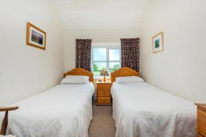 Dos camas individuales en una habitación con ventana. en Felin Fach, en Haverfordwest