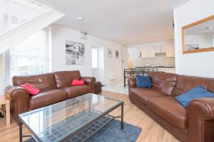 sala de estar con 2 sofás y mesa de cristal en The Nook, en Manorbier