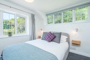 ein Schlafzimmer mit einem Bett und zwei Fenstern in der Unterkunft Ty Olwen in Haverfordwest