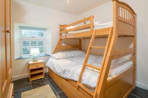 1 Grove Stables في سانت دافيدز: غرفة نوم بها سريرين بطابقين ونافذة