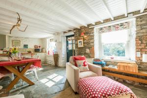 a living room with a table and a kitchen at 1 Penally Boathouse Mews in Cardigan +32 photos