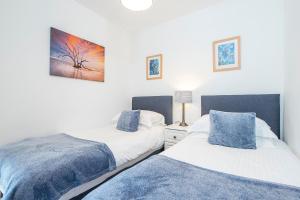 En eller flere senge i et værelse på Amroth Cottage