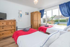 Un dormitorio con dos camas y una ventana. en Sandgrove, en Saundersfoot