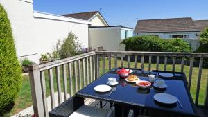 una mesa azul con comida en el balcón en Sandgrove, en Saundersfoot