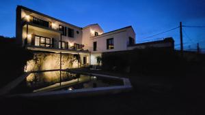 a house at night with a pool in front of it at La casa nido in Torrejón el Rubio
