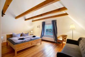 una camera da letto con un letto, un divano e una finestra di Haus am See - zur blauen Tür a Templin