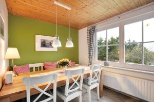una sala da pranzo con tavolo e sedie in legno di Haus am See - zur blauen Tür a Templin