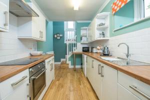 eine Küche mit weißen Schränken und blauen Wänden in der Unterkunft Inkerman House in Saundersfoot