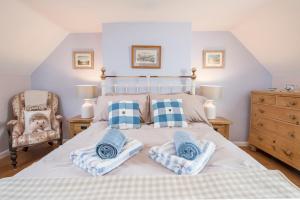 a bedroom with a large bed with blue and white pillows at Drws Gobaith-West in Haverfordwest