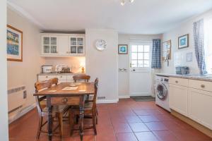 eine Küche mit einem Tisch und Stühlen sowie einer Waschmaschine in der Unterkunft Pilgrims in Haverfordwest + 21 Fotos