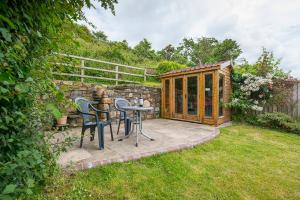 eine Terrasse mit einem Tisch und Stühlen im Garten in der Unterkunft Ivy Cottage in Haverfordwest