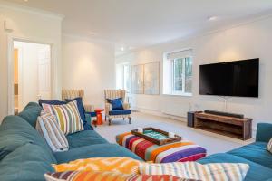 Una sala de estar con un sofá azul y un televisor de pantalla plana. en Old Farm East Orielton, en Pembroke