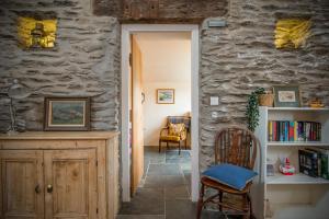 ein Raum mit einer Steinmauer und einem Tisch und einem Stuhl in der Unterkunft The Smithy in Haverfordwest
