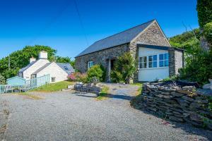 ein Steinhaus mit einer Steinmauer in der Unterkunft The Smithy in Haverfordwest