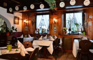 a restaurant with tables and chairs and clocks on the wall at Hotel Wistub Aux Mines d'Argents in Sainte-Marie-aux-Mines