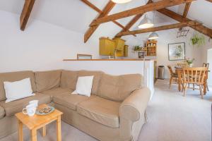 ein Wohnzimmer mit Sofa und Tisch in der Unterkunft Weavers Cottage in Lampeter-Velfrey
