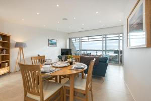 a dining room and living room with a table and chairs at 16 Waters Edge in Tenby