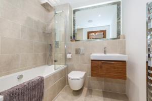 a bathroom with a toilet and a sink and a shower at 16 Waters Edge in Tenby +17 photos