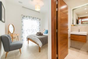 a bedroom with a bed and a bathroom with a sink at 16 Waters Edge in Tenby