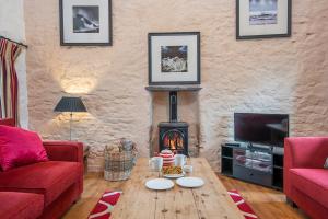 un salon avec une table et une cheminée dans l'établissement Nolton Coach House, à Haverfordwest