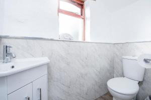 une salle de bain blanche avec toilettes et lavabo dans l'établissement Nolton Coach House, à Haverfordwest 21 autres photos