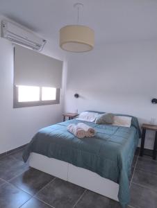 a bedroom with a bed with two towels on it at Departamento Malbec House in Maipú