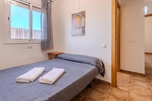 ein Schlafzimmer mit einem Bett mit zwei Handtüchern darauf in der Unterkunft Villa Luz Lloret Lux with Pool in Lloret de Mar + 32 Fotos