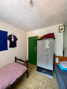 a room with two beds and a cabinet in it at República Engenho Quarto Triplo II in Ouro Preto